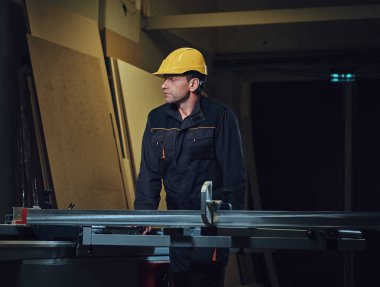 Woodworker tahta masada yaslanmış.