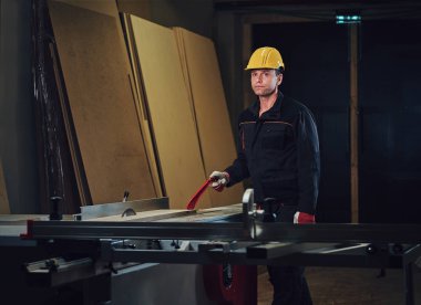 Woodworker tahta masada yaslanmış.