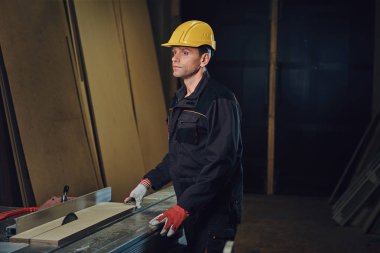 Woodworker tahta masada yaslanmış.