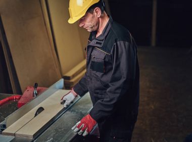 Woodworker tahta masada yaslanmış.