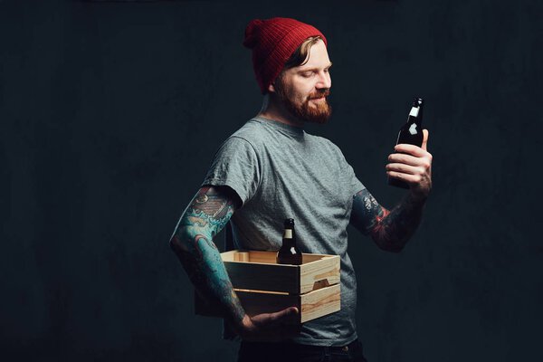 man holds  box with beer bottles.