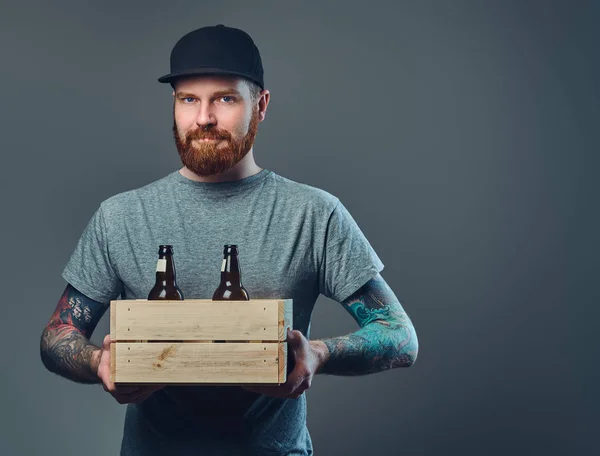 Homem segura caixa com garrafas de cerveja . — Fotografia de Stock