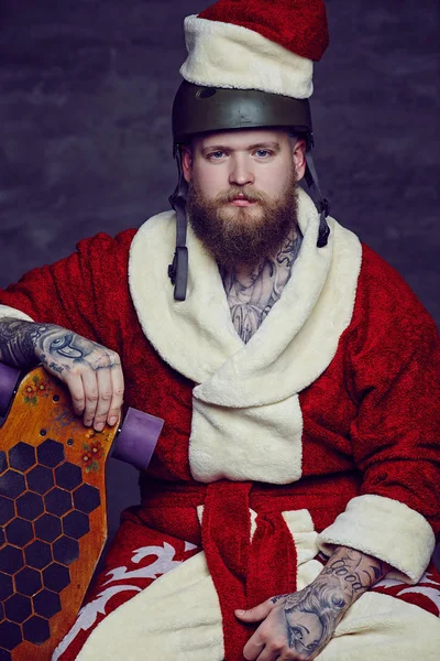 Ein Mann in Weihnachtsmannkleidung hält Longboard in der Hand. — Stockfoto