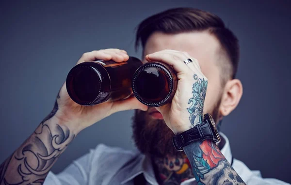 Un uomo che guarda tra le bottiglie di birra . — Foto Stock