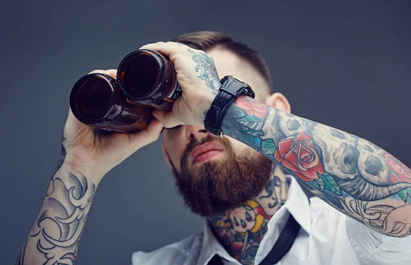 Un hombre mirando entre botellas de cerveza . — Foto de Stock
