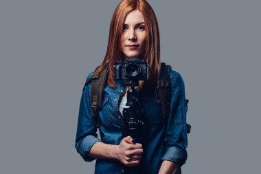 Bir kadın fotoğraf makinesi tutar.