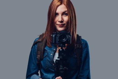 Bir kadın fotoğraf makinesi tutar.