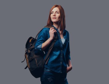 Gri arka plan üzerinde bir kot gömlek giymiş bir gezgin Kızıl saçlı kadın portresi.