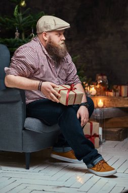 Hafif tombul hippi erkek Noel dekorasyonu ile bir odada portresi.