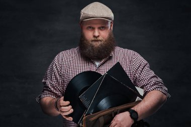 Hafif sakallı hippi müzik aşığı erkek portresi vinil kayıtları tutar.
