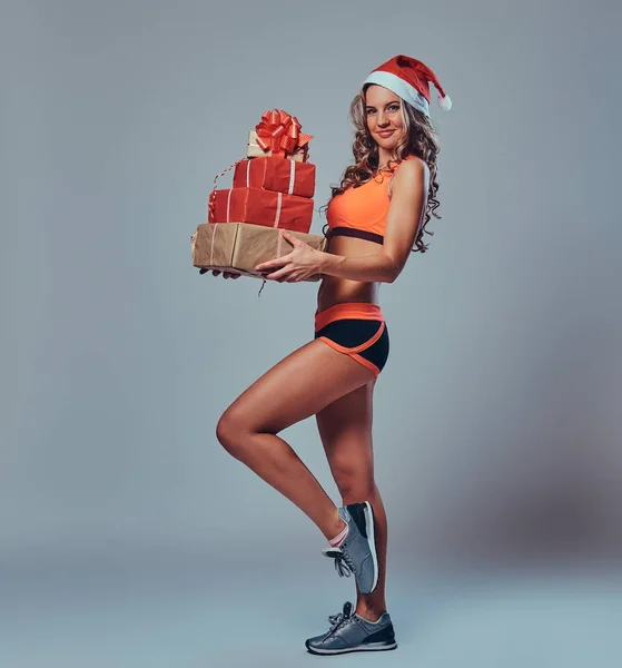 Hela Kroppen Bilden Blond Sportig Kvinna Santa Hatt Rymmer Julklappar — Stockfoto