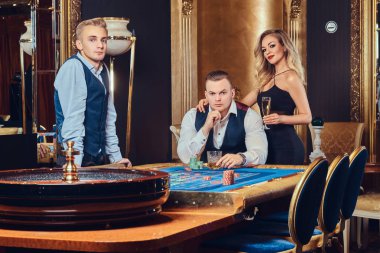 Krupiye ile şık erkek ve çekici sarışın kadın bir Casino rulet oynamak.