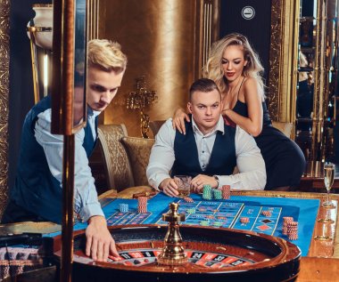 Krupiye ile şık erkek ve çekici sarışın kadın bir Casino rulet oynamak.
