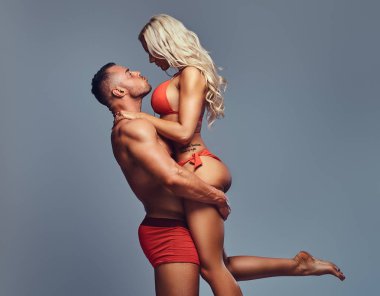 Çekici fitness çift. Kaslı erkek silah seksi sarışın kadın tutar.
