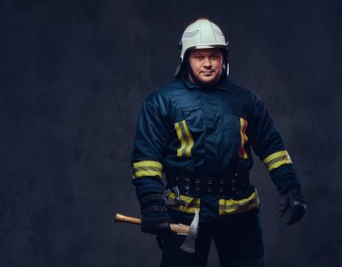 Stüdyo portre üniformalı bir itfaiye eri ve balta tutar.
