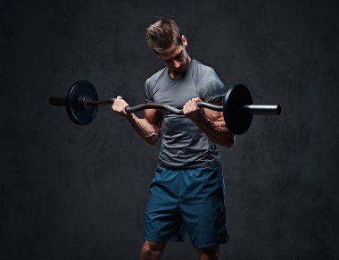 Atletik erkek pazı halter egzersiz. Stüdyo portre gri arka plan üzerinde.