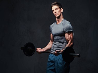 Atletik erkek pazı halter egzersiz. Stüdyo portre gri arka plan üzerinde.