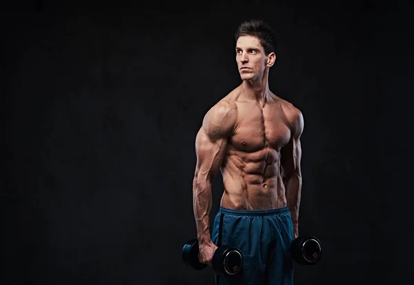 Athletic shirtless male holds dumbbells. — Stock Photo, Image