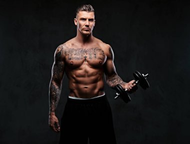 Kaslı biri dumbbells ile yapıyor.