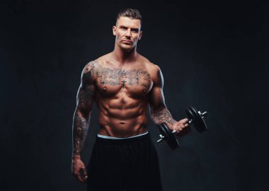 Kaslı biri dumbbells ile yapıyor.