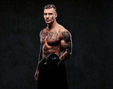 Kaslı biri dumbbells ile yapıyor.