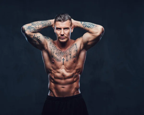 어두운 배경 위에 근육 문신된 남자. — 스톡 사진