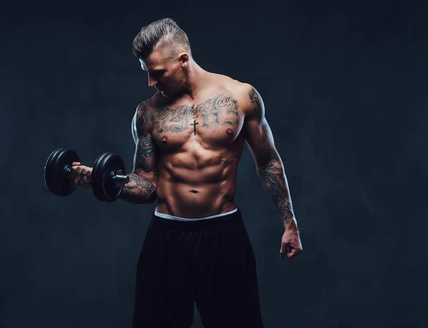 Um homem musculoso fazendo exercícios com halteres . — Fotografia de Stock