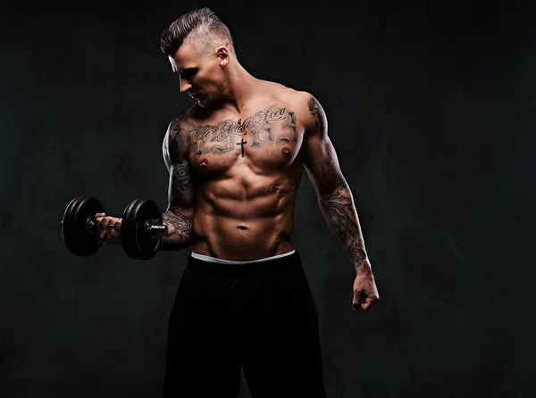 A muscular man doing exercises with dumbbells. — Stock Photo, Image