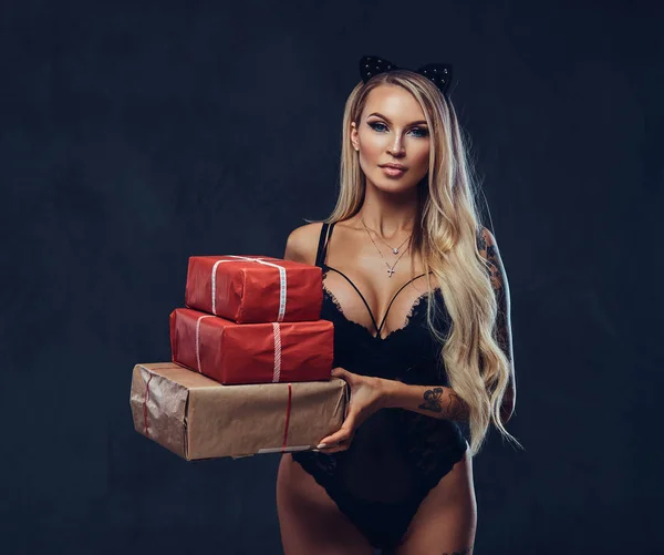 Сексуальна блондинка тримає подарунок на темному тлі в мереживі — стокове фото