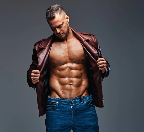 Muscular male dressed in a jacket and jeans. — Stock Photo, Image