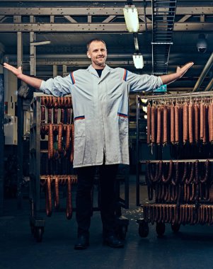 Sosis depolama birimindeki bir mutfak beyaz elbise giymiş bir erkek portresi.