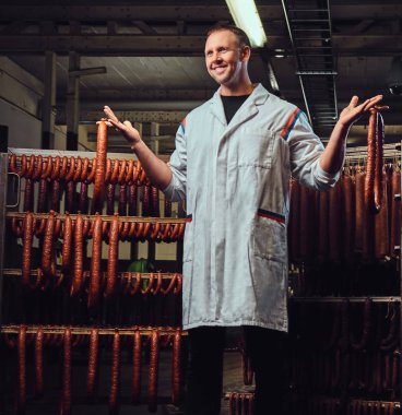 Sosis depolama birimindeki bir mutfak beyaz elbise giymiş bir erkek portresi.