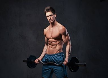 Atletik gömleksiz erkek pazı halter egzersiz gri arka plan üzerinde.