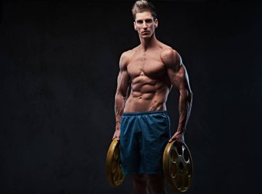 Stüdyo portre gömleksiz atletik erkek ectomorph halter ağırlık gri arka plan üzerinde tutar..