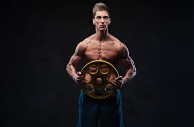 Studio portrait of ectomorph shirtless athletic male holds barbell weight over grey background. clipart