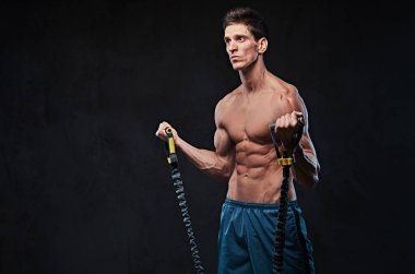 Lateks direniş band ile gömleksiz atletik erkek ısıtır.