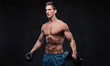 Gömleksiz atletik erkek yapıyor dumbbells ile yanal baş egzersizler omuzlar.