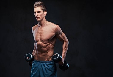 Gömleksiz atletik erkek yapıyor dumbbells ile yanal baş egzersizler omuzlar.