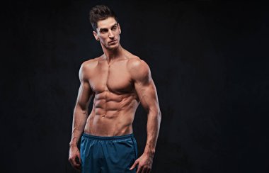 Stüdyo portre ectomorph kas gömleksiz erkek koyu gri arka plan üzerinde.