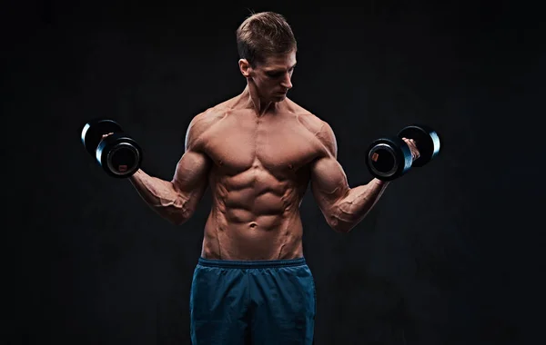 运动裸男肱二头肌哑铃锻炼在黑暗的灰色背景 — 图库照片