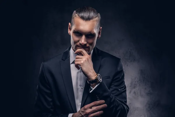 Handsome businessman against a dark background. — Stock Photo, Image