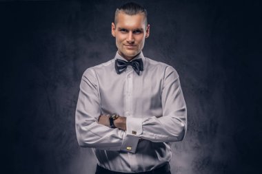 Yakın çekim, karanlık bir arka plan beyaz gömlekli rahat yakışıklı bir adam portresi.