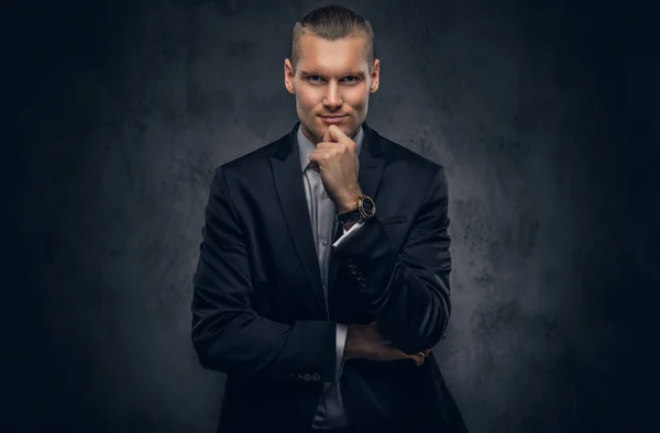 Handsome businessman against a dark background. — Stock Photo, Image