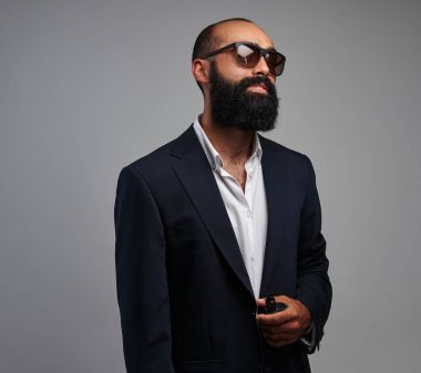 Elektronik bir boru ile iş takım elbiseli sakallı bir erkek portresi stüdyo.