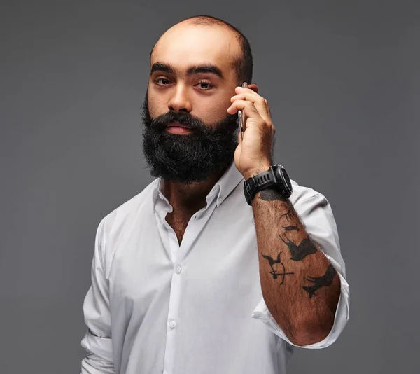 배경에 전화를 셔츠에서 수염된 문신된 남자의 초상화 — 스톡 사진