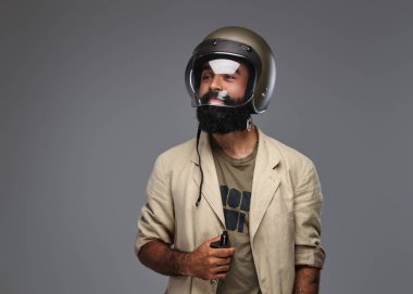 Bir motosiklet kask sigara elektronik sigara içinde sakallı hippi. Gri bir arka plan üzerinde izole.