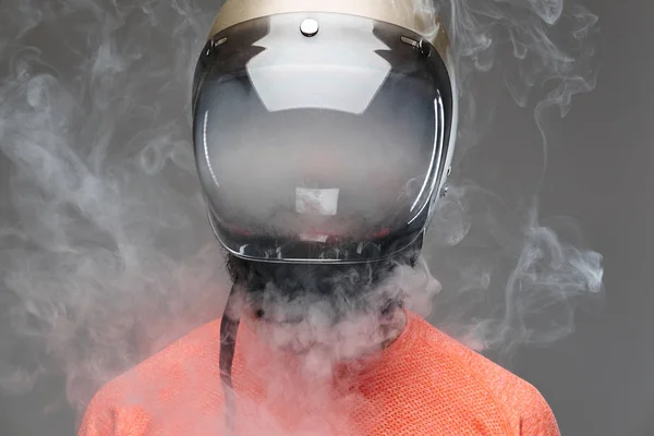オートバイのヘルメットが電子タバコを吸ってで流行に敏感 灰色の背景に分離 — ストック写真