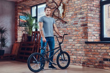 T-shirt ve kot Bmx. Studio atış ile ayakta yakışıklı adam.