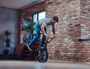 Beyaz adam bir stüdyoda Bmx ile akrobatik bir şekil yapar. Stüdyo vurdu.