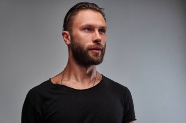Sakal ve saç modeli tarafına seyir siyah t-shirt ile yakışıklı bir erkek.